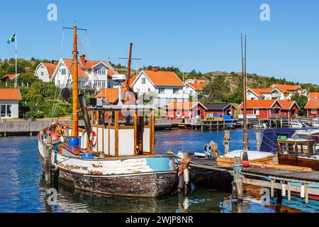 Old fishing boat at a jetty in a fishing village harbour on the Swedish west coast on a sunny summer day, Hamburgsund, Bohuslaen, Sweden Stock Photo