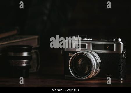 Vintage camera with lens on a dark wooden table Stock Photo