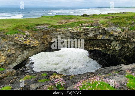 Fairy bridges, impressive stone arches near Tullan Strand, one of Donegals surf beaches, framed by a scenic back drop provided by the Sligo-Leitrim Mo Stock Photo