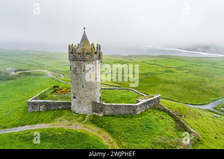 Aerial view of Doonagore Castle, round 16th-century tower house with a small walled enclosure located near the coastal village of Doolin in County Cla Stock Photo