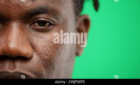 Man's face, close-up, on a green background. Stock Photo