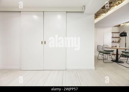 White wooden sliding doors to a room in an industrial loft apartment. Stock Photo