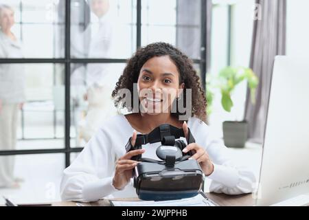 Girl in VR glasses of virtual reality with gamepad playing game Stock Photo