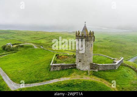 Aerial view of Doonagore Castle, round 16th-century tower house with a small walled enclosure located near the coastal village of Doolin in County Cla Stock Photo