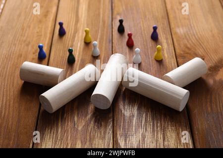 Wooden blocks as barrier blocking way for small human figures on table, closeup. Development through obstacles overcoming Stock Photo