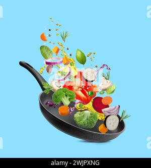 Different vegetables, oil, frying pan in air on light blue background Stock Photo