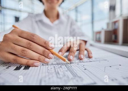 female architect designer working on blueprints at office Stock Photo