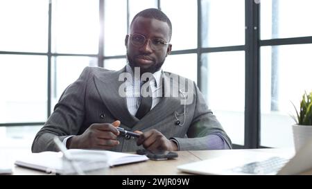 A businessman man in a close-up in a jacket looks at the camera in the office Stock Photo