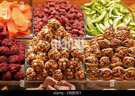 Organic dry fruits and nuts piles sold on a market stall Stock Photo