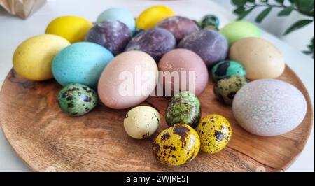 The colorful Easter eggs arranged beautifully on a rustic wooden platter. Stock Photo