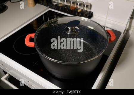 Empty saucepan with marble coating inside and glass lid on induction ceramic hob for cooking Stock Photo