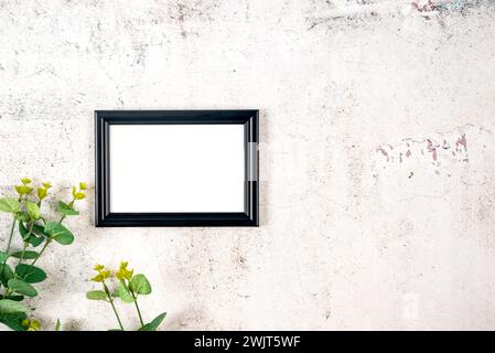 Picture frame mockup with eucalyptus branches on grey concrete background, Blank mockup for artwork, print or photo presentation. Stock Photo