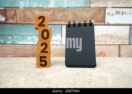 Hand flipping block 2024 to 2025 text on table. Resolution, time, plan, goal, motivation, reboot, countdown and New Year holiday concepts Stock Photo