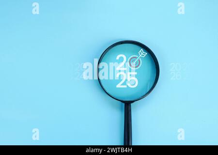 Magnifying glass and targets 2025. Concept of new year 2025, beginning of success, challenge or career path, change, planning, goals, challenges and n Stock Photo