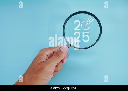 Magnifying glass and targets 2025. Concept of new year 2025, beginning of success, challenge or career path, change, planning, goals, challenges and n Stock Photo