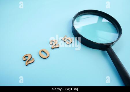 Magnifying glass and targets 2025. Concept of new year 2025, beginning of success, challenge or career path, change, planning, goals, challenges and n Stock Photo