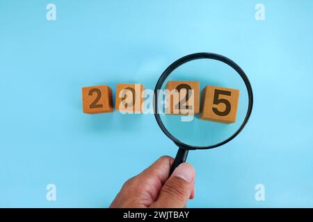 Magnifying glass and targets 2025. Concept of new year 2025, beginning of success, challenge or career path, change, planning, goals, challenges and n Stock Photo