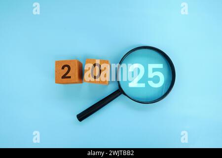 Magnifying glass and targets 2025. Concept of new year 2025, beginning of success, challenge or career path, change, planning, goals, challenges and n Stock Photo