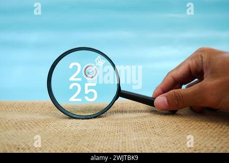 Magnifying glass and targets 2025. Concept of new year 2025, beginning of success, challenge or career path, change, planning, goals, challenges and n Stock Photo