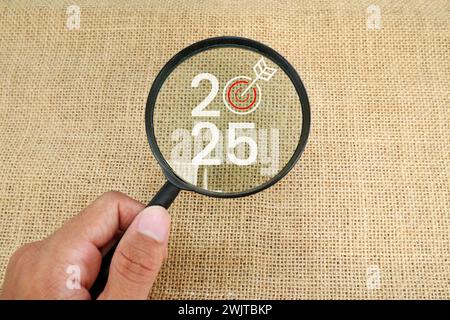 Magnifying glass and targets 2025. Concept of new year 2025, beginning of success, challenge or career path, change, planning, goals, challenges and n Stock Photo