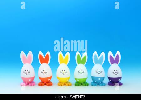 Easter bunny eggs decorated in rainbow spectrum colors on gradient blue white background. Minimal cute fun composition with Lgbt trans theme. Stock Photo