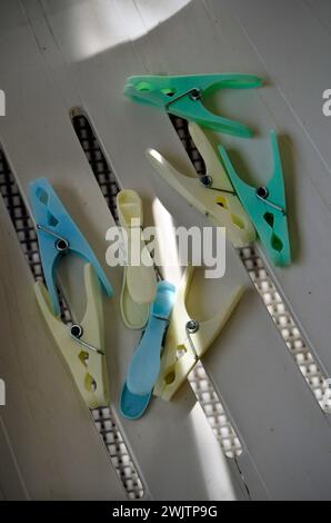 plastic clothes pegs laying on plastic garden chair seat Stock Photo