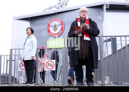 London, UK. 17th Feb, 2024. A Brentford fan reads a match day programme outside the stadium ahead of the Premier League match at Gtech Community Stadium, London. Picture credit should read: Paul Terry/Sportimage Credit: Sportimage Ltd/Alamy Live News Credit: Sportimage Ltd/Alamy Live News Stock Photo