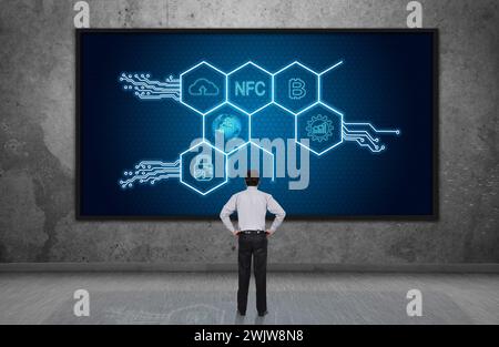 Businessman looking on digital screen with hexagons hologram. Virtual reality and global networking concept. Stock Photo