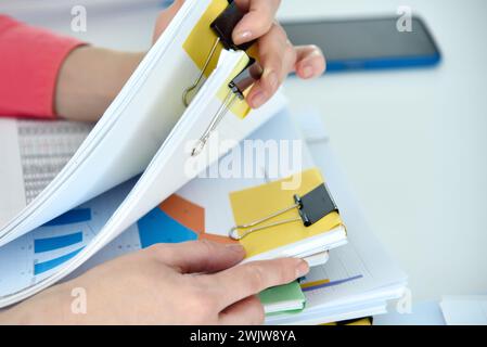 Businesswoman hands holding business reports stacks and stock charts. Financial and paperwork concept Stock Photo