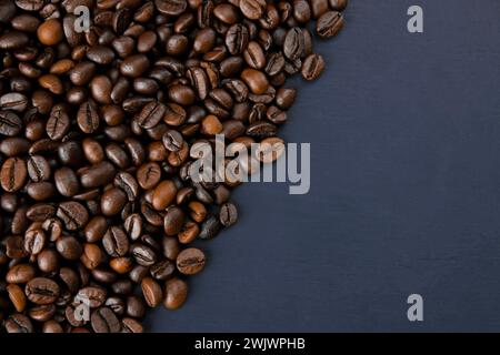 Roasted coffee beans on a dark background. Coffee beans texture. Coffee in beans on dark background. Food background of coffee beans. Abstract backgro Stock Photo