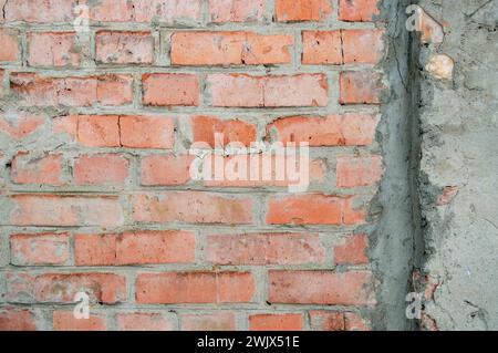 Hand made brick wall made from bricks, abstract background texture with old dirty and vintage style pattern. Red grunge brick in the wall with gray pu Stock Photo