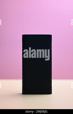 black battery for smartphone on orange and pink background Stock Photo