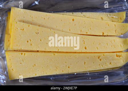 Slices of Egyptian Rumi cheese, also called gebna romiya or gebna turkiya, Roumi, Romi also Romy, middle Eastern parmesan hard cheese, has a pungent s Stock Photo