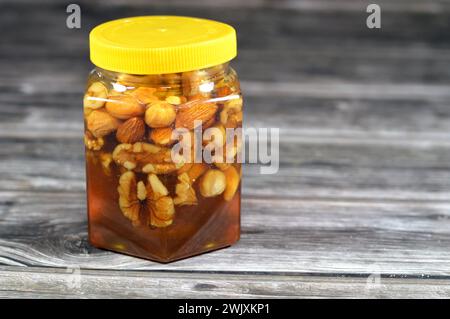 Jar of tasty cashew nuts with honey on white background Stock Photo - Alamy