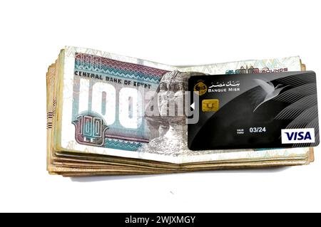 Cairo, Egypt, February 12 2024: Stack of Egyptian money banknotes of 100 Hundred pounds and Banque Misr or Egypt Bank electronic payment VISA card for Stock Photo