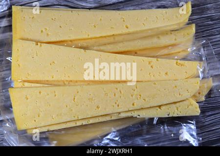 Slices of Egyptian Rumi cheese, also called gebna romiya or gebna turkiya, Roumi, Romi also Romy, middle Eastern parmesan hard cheese, has a pungent s Stock Photo