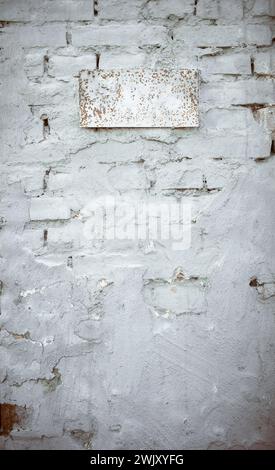 Old brick and plaster wall texture background. Painted distressed wall surface. Messy building facade with damaged plaster. Old broken brick wall made Stock Photo