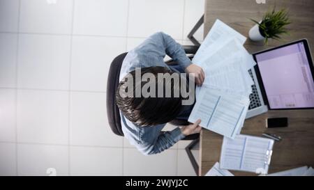 A male office worker is scattering papers Stock Photo
