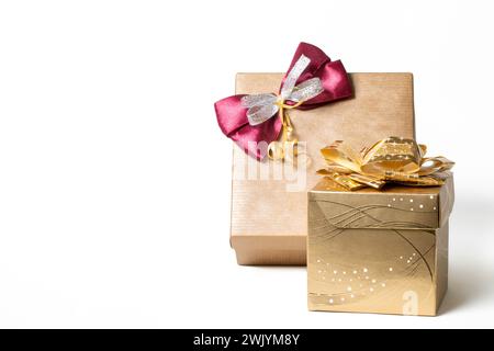 Two gift boxes with merlot and golden bows in golden colors isolated on the white background Stock Photo