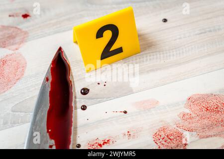 Augsburg, Bavaria, Germany - February 16, 2024: Symbolic image crime scene of a murder case staged scene. Man smeared with blood lying on the ground with police evidence markings *** Symbolbild Tatort eines Mordfalls gestellte Szene. Mit Blut verschmierter Mann liegt auf dem Boden mit Beweismittel Markierungen der Polizei Stock Photo