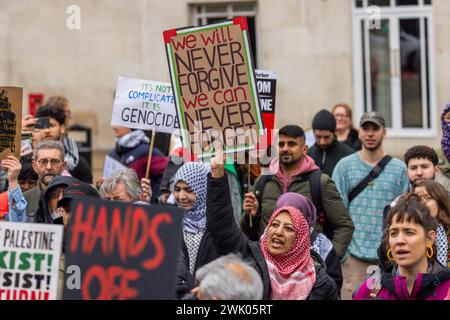 Leeds, UK. 17 FEB, 2024. A lady holds up a sign that reads 'We Will Never forgive, we can never forget' as Pro Palestine demonstrators gather in City Square to listen to speeches. Credit Milo Chandler/Alamy Live News Stock Photo