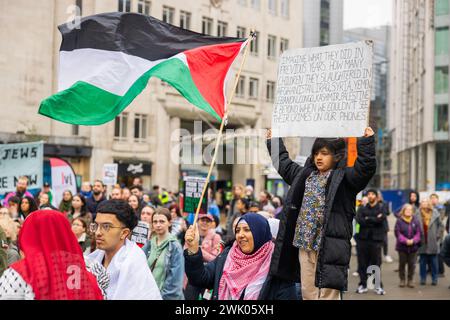 Leeds, UK. 17 FEB, 2024. A young child at the pro palestine protest in Leeds city square holds a sign with a list of countries that crimes against children are alleged to have been commited in. Credit Milo Chandler/Alamy Live News Stock Photo