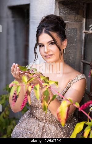 Close up portrait of a teen brunette girl in a golden dress. Ready for prom Stock Photo