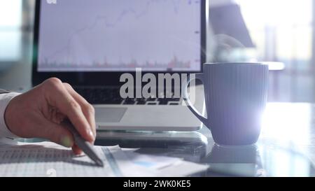 Checking charts on the Internet and documentation Stock Photo