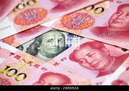 US dollars surrounded by Chinese yuan banknotes. Concept of trade war between the China and USA, economic, sanctions Stock Photo