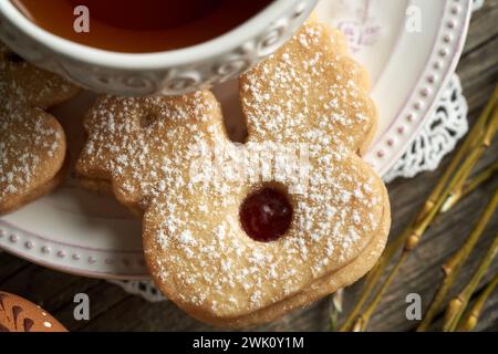 Chicken shaped homemade Linzer Easter cookie near a cup of tea Stock Photo