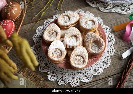 Homemade Linzer cookies in the shape of eggs with Easter decoration on a table Stock Photo