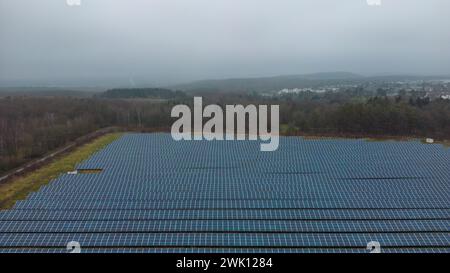 Solar panels on ground with rows, mountains in distance Stock Photo