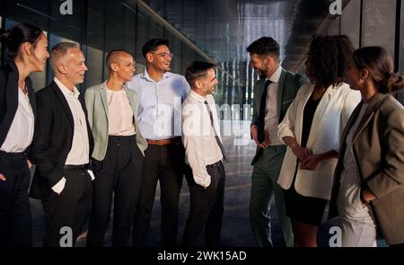 Presentation meeting of male team leaders smiling introducing themselves standing in the hallway. Stock Photo