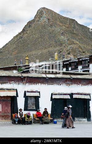 Locals socially congregate and rest outside Tashi Lhunpo Monastery in Shagatse, Tibet Autonomous Region. Stock Photo